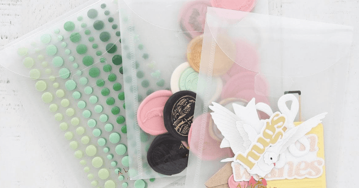 3 clear storage pouches from Altenew filled with enamel dots, ready to use wax seals, and ready to use die-cuts